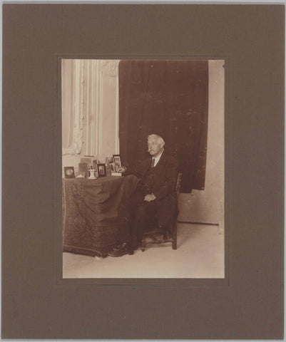 Mr. Retra sitting at a table with framed photos, c. 1920 Canvas Print