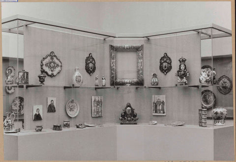 Display case with ceramic objects, including a mirror frame, plates, a bust and a firebox, c. 1959 Canvas Print