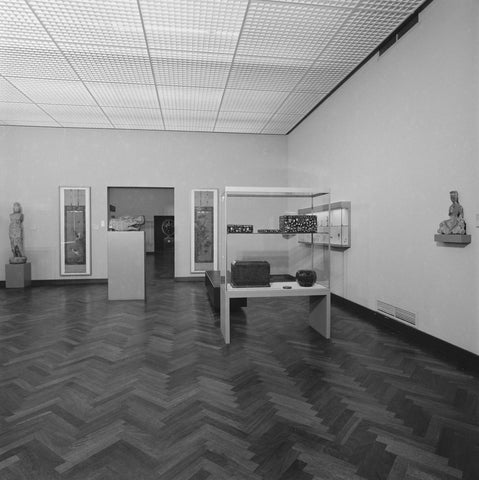 Room with images, objects in display cases and at the back a view of a room where a statue of Shiva stands, 1983 Canvas Print