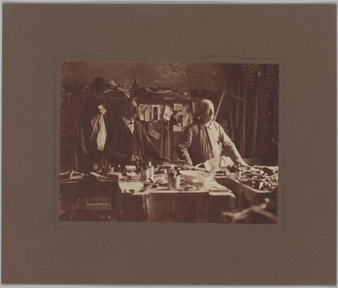 H. Martens (left) and A. Besier standing behind a work table, c. 1920 Canvas Print