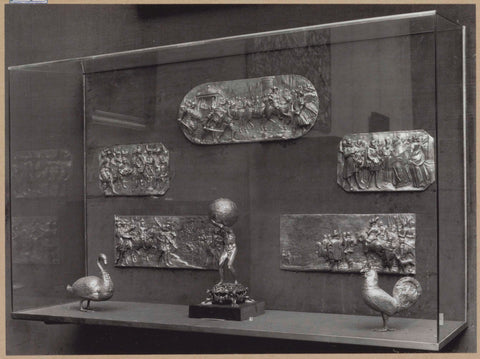 Display case with metal objects: plaques, an Atlas figure and two bird figures, c. 1959 Canvas Print