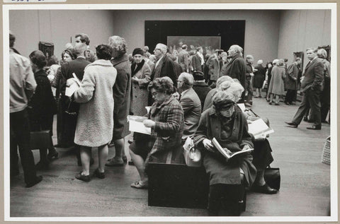 Visitors view the exhibition, some read the catalogue, sitting on benches, c. 1969 Canvas Print