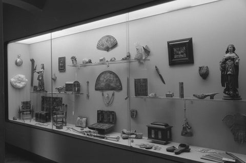 Display case with various objects including statues, fans, slippers and boxes, 1953 Canvas Print