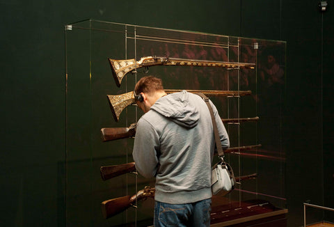 Man with headphones for a display case with guns, 2009 Canvas Print