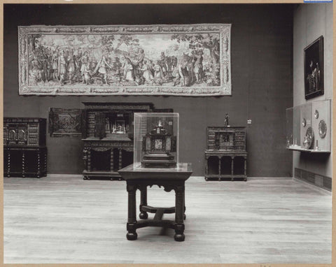 Room with furniture including art cabinets, a table, a tapestry and a display case with objects of precious metal, 1962 Canvas Print