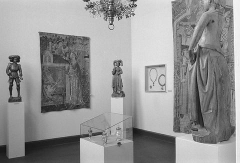 Room with essay of 15th and 16th century arts and crafts sculptures on pedestals, tapestry and display case, 1952 Canvas Print