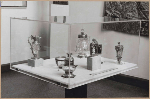 Display case with various objects of glass and metal, including a jug, c. 1959 Canvas Print