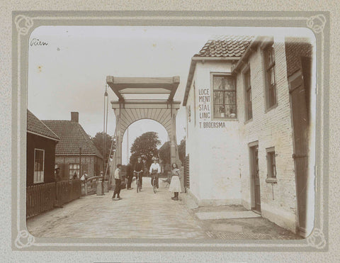 Street in Rien with drawbridge, accommodation and parking T. Broersma, cyclists and children, Folkert Idzes de Jong, c. 1905 - c. 1907 Canvas Print