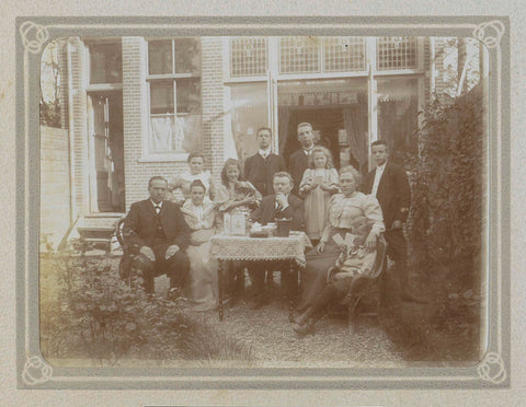 Groep mannen, vrouwen en kinderen bij een tafel achter een huis, Folkert Idzes de Jong, c. 1905 - c. 1907 Canvas Print