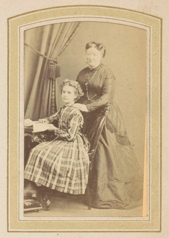 Portrait of a girl in a dress with Scottish check and a woman in a dress at a table with books, anonymous, c. 1860 - c. 1900 Canvas Print