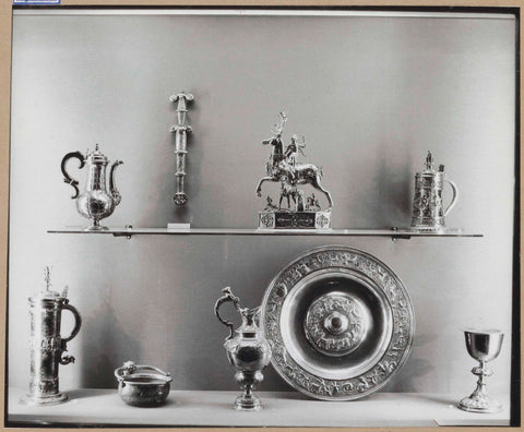 Display case with various metal objects including a bowl, jugs, drinking cups and a table dispenser, c. 1959 Canvas Print