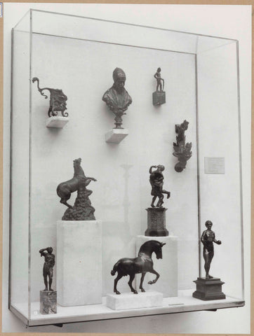 Display case with various objects including small images of horses and human figures, c. 1959 Canvas Print