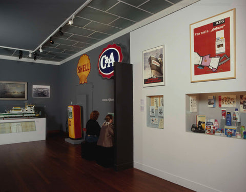 Room with, among other things, logos of Shell and C&A, a model of a pusher boat and a petrol pump, c. 2001 Canvas Print