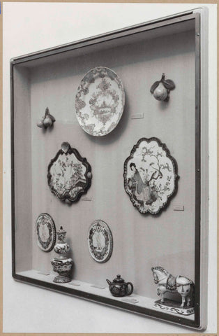 Display case with ceramic objects, including a horse, artificial fruit and a bowl, c. 1959 Canvas Print