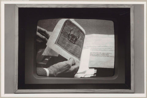 Television screen with a hand on it that flips through a book, c. 1975 Canvas Print