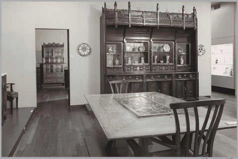 Room with furniture including chairs, a table, a cupboard with ceramics and a passage with a view of a cupboard, 1983 Canvas Print