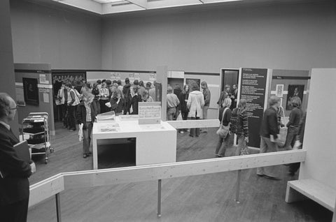 Visitors in a room with various objects and in the foreground an usher, c. 1975 Canvas Print