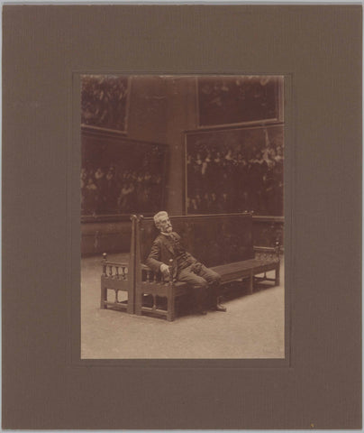 W.J. Steenhoff sitting on a bench in a room with archer's pieces, c. 1920 Canvas Print