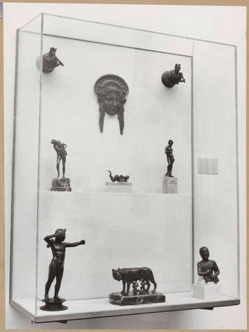 Display case with small images of human figures and a she-wolf with Romulus and Remus, c. 1959 Canvas Print