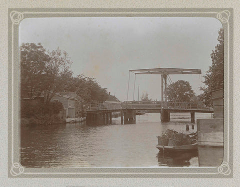 Drawbridge over a water near houses, in the foreground a boat laden with thatched baskets, Folkert Idzes de Jong, c. 1905 - c. 1907 Canvas Print