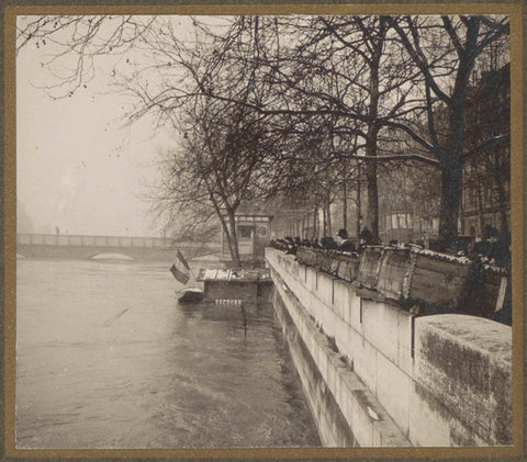 People view the high water level of the Seine in Paris from behind book stalls on the quay, G. Dangereux, 1910 Canvas Print