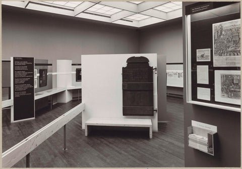 Room with various objects including a wooden door with Latin inscription, information panels and a sofa for visitors, c. 1975 Canvas Print