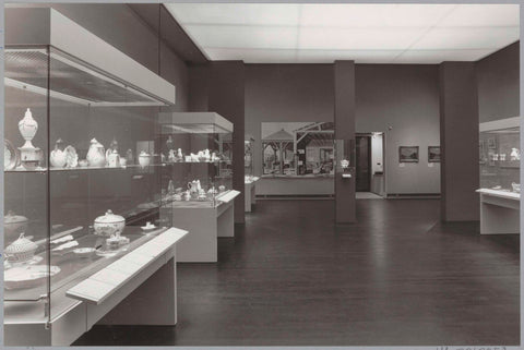 Room with various objects on the wall and in display cases and a passage, c. 1988 Canvas Print