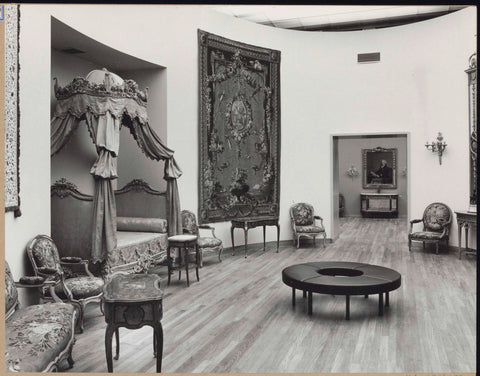 Room with furniture including tables and chairs, a tapestry, a bed and in the middle a round sofa for visitors, 1962 Canvas Print