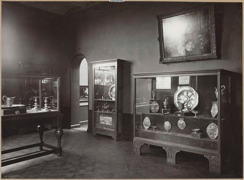 Room with display cases with silver objects, including candlesticks and bowls, and a passageway, c. 1920 - c. 1940 Canvas Print