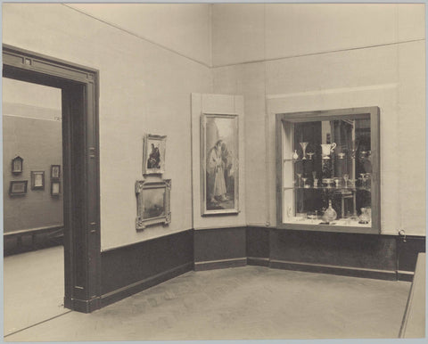 Corner of a room with paintings exhibited between a passage and a display case with, among other things, glasses, 1934 Canvas Print