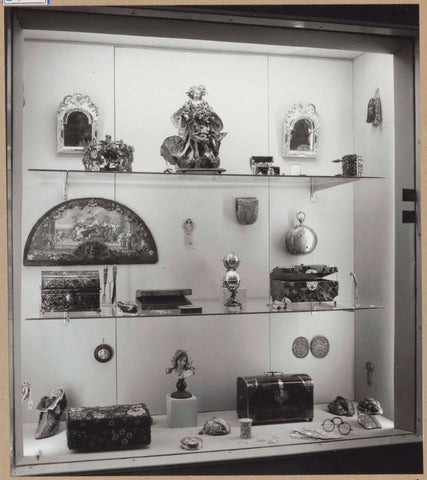 Display case with various objects including caskets, mirrors, a fan, glasses, a clay bust of a woman, c. 1959 Canvas Print