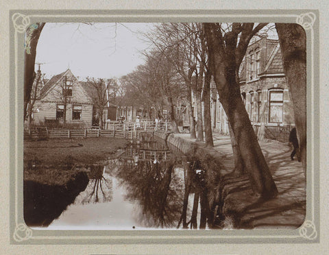 Dorpsstraat with houses, a ditch and children with bicycles on a bridge, Folkert Idzes de Jong, c. 1905 - c. 1907 Canvas Print