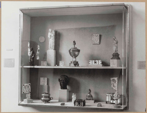 Display case with various objects including small statues, boxes and a bust, c. 1959 Canvas Print