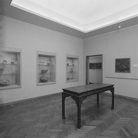 Room with a table in the middle, objects in wall display cases and a passage at the back, 1983 Canvas Print