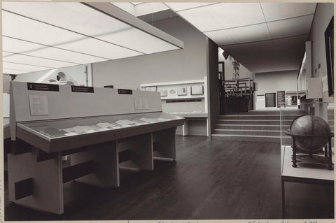 Room with various objects including books in display cases, a globe and a staircase, c. 1975 Canvas Print