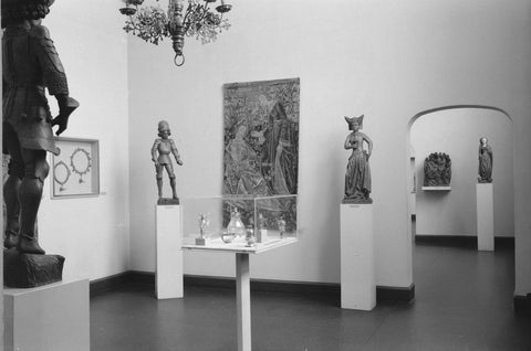 Room with arrangement of Medieval arts and crafts: display cases, statues on pedestals and passageway with view of the image, 1953 Canvas Print