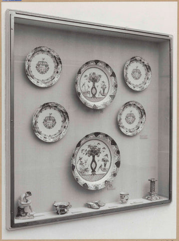 Display case with ceramic objects, including plates, dishes, muzzles and a seated figure, c. 1959 Canvas Print