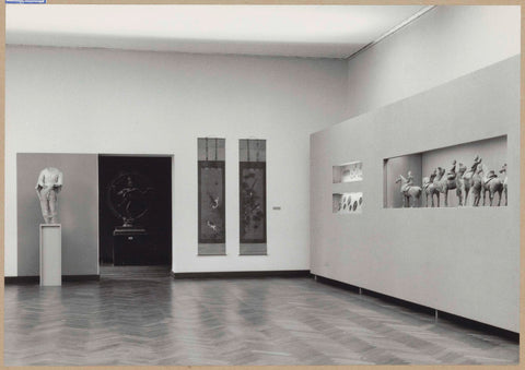 Room with a sculpture and paintings next to a passageway, right-built display cases with various objects, 1961 Canvas Print